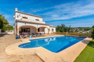 a villa with a swimming pool and a house at Villa Diego - PlusHolidays in Benissa
