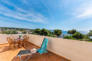 una persona sentada en una silla en un balcón con vistas al océano en Villa Diego - PlusHolidays, en Benissa