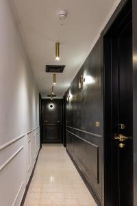 - un couloir avec des portes noires et du carrelage dans l'établissement Theodor Brown Rothschild Tel-Aviv, a member of Brown Hotels, à Tel Aviv