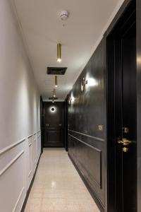a hallway with black doors and a tile floor at Theodor Brown Rothschild Tel-Aviv, a member of Brown Hotels in Tel Aviv