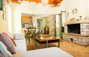 a living room with a couch and a fireplace at Drakos Vacation Houses in Stoupa