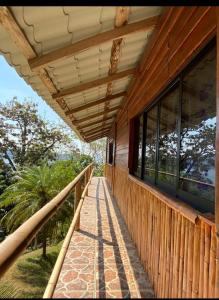 a wooden porch of a house with windows at Cabañas cascadas encantadas in Catemaco