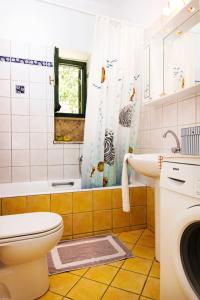 a bathroom with a toilet and a sink and a shower at Drakos Vacation Houses in Stoupa +40 photos