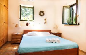 a bedroom with a bed with two towels on it at Drakos Vacation Houses in Stoupa