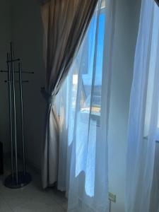 a bedroom with a window with white curtains at Burj Al Dana Four seasons Hotel in Al Jubail