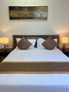 um quarto com uma cama branca e 2 candeeiros em Burj Al Dana Four seasons Hotel em Al Jubail