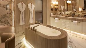 a bathroom with a bath tub and a sink at Jumeirah Mina Al Salam Dubai in Dubai