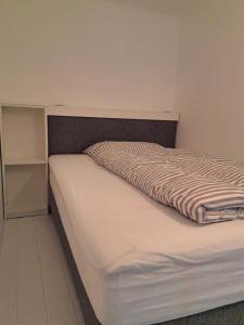 a bed in a small room with a bedskirtspectspectssenalsenalsenalsenal at Ruhige Art-Garconniere mit Balkon in Vienna