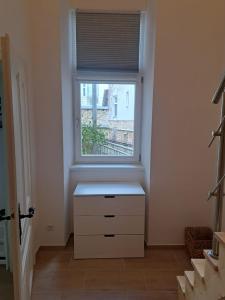 a room with a window and a white dresser at Ruhige Art-Garconniere mit Balkon in Vienna