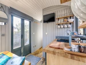 a kitchen with a counter with a sink and a window at Pass the Keys Whitstable Shepherds Hut minutes from the Harbour in Whitstable