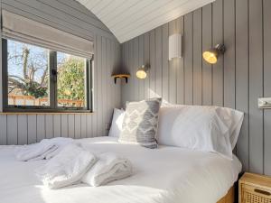 a bedroom with two white beds and a window at Pass the Keys Whitstable Shepherds Hut minutes from the Harbour in Whitstable
