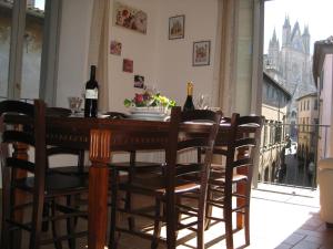 a dining room table with chairs and bottles of wine at Il Terrazzino sul Duomo in Orvieto