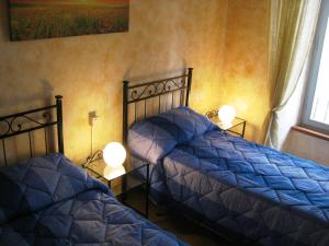 a bedroom with two beds with blue comforters and a window at Il Terrazzino sul Duomo in Orvieto