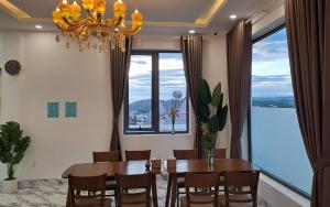 uma sala de jantar com uma mesa e cadeiras e um lustre em Uncle Park's Villa Son Trang 엉클팍 em Da Lat