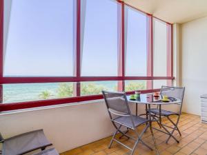 a table and chairs in a room with windows at Appartement Hendaye, 1 pièce, 3 personnes - FR-1-2-392 in Hendaye
