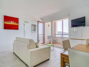 a living room with a white couch and a table at Appartement Hendaye, 1 pièce, 3 personnes - FR-1-2-392 in Hendaye