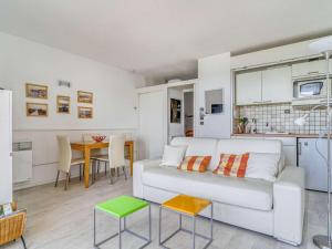 a living room with a white couch and a table at Appartement Hendaye, 1 pièce, 3 personnes - FR-1-2-392 in Hendaye