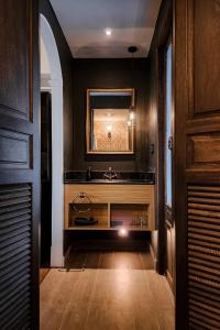 a bathroom with a sink and a mirror at The Quba Boutique Hotel Pattaya in Pattaya Central