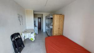 een kleine kamer met een bed en een kast bij Cap Confort in Cap d'Agde