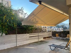 - un grand parasol blanc au-dessus d'une terrasse dans l'établissement Aphrodite-Recently Renovated Modern Apartment, à Athènes