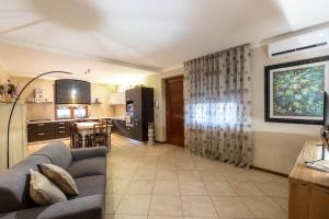 GanfardineにあるNadia Green House Sommacampagna Veronaのソファとキッチンのあるリビングルーム