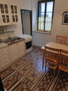 cocina con mesa, fregadero, mesa y sillas en Apartment Poluotok, en Zadar