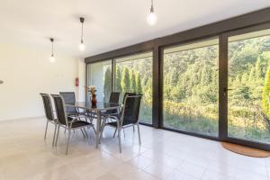ein Esszimmer mit einem Tisch und Stühlen sowie großen Fenstern in der Unterkunft Beautiful house 15 min away from Bilbao in Laudio/Llodio