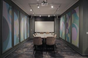 a conference room with a table and chairs and a whiteboard at President Hotel&Restaurant&SPA in Trostyanets