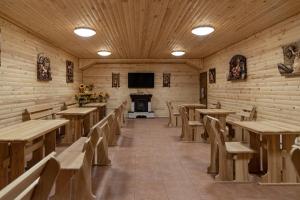 a restaurant with wooden tables and chairs and a tv at President Hotel&Restaurant&SPA in Trostyanets