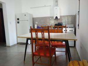 y cocina con mesa, sillas y nevera. en El Andaluz en San Marcos Sierras