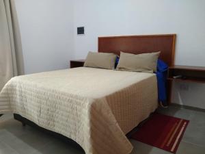 1 dormitorio con 1 cama grande y cabecero de madera en El Andaluz en San Marcos Sierras