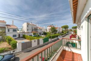 - un balcon avec vue sur une rue avec des maisons dans l'établissement Casa da Praia, à Estoril