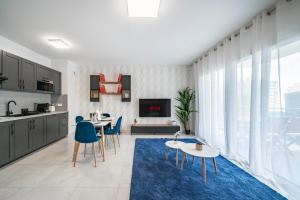 a kitchen and living room with a blue rug at Frontière Monaco, Terrasse Vue Mer, Tour Odeon - AP in Beausoleil