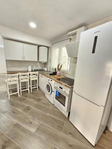 cocina con electrodomésticos blancos y nevera blanca en Apartamento con Playa del Arenal a los pies en Platja de l'Arenal