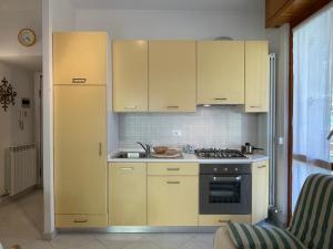 - une cuisine avec des placards jaunes et un évier dans l'établissement [600 metri dal Mare] - Tranquillo e con Wi-Fi, à Pietra Ligure