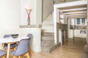 een eetkamer met een tafel en stoelen en een trap bij Appartamento moderno Second House Catania 26 in Catania
