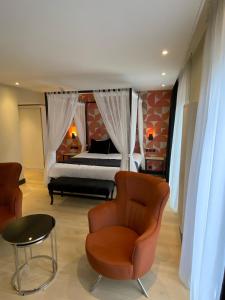 a bedroom with a bed and a chair and a table at Alp de Veenen Hotel in Amstelveen