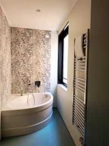 La salle de bains est pourvue d'une baignoire et d'une fenêtre. dans l'établissement Hotel Restaurant Forum, à Beausoleil