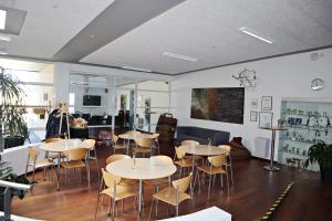 a restaurant with tables and chairs in a room at Plexus Hytterne in Holstebro