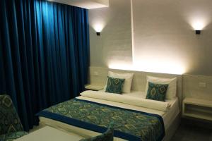 a hotel room with a bed with blue curtains at Shellghada Blue Beach in Hurghada