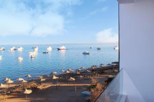 a view of a beach with umbrellas and boats in the water at Shellghada Blue Beach in Hurghada