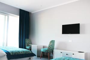 a hotel room with two beds and a television on the wall at Shellghada Blue Beach in Hurghada
