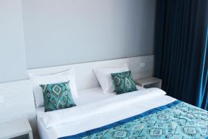 a bedroom with a white bed with two pillows at Shellghada Blue Beach in Hurghada