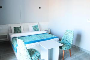 a small room with a bed and a desk and chairs at Shellghada Blue Beach in Hurghada