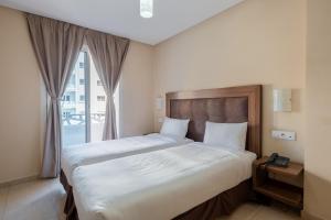 a hotel room with two beds and a window at Hotel Etoile Du Nord in Tangier