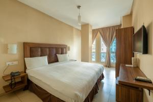 um quarto com uma cama grande e uma televisão em Hotel Etoile Du Nord em Tânger