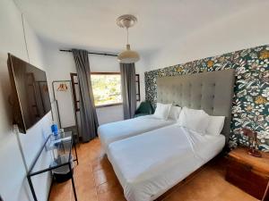 um quarto com uma grande cama branca e uma janela em Sol Port Soller em Port de Sóller