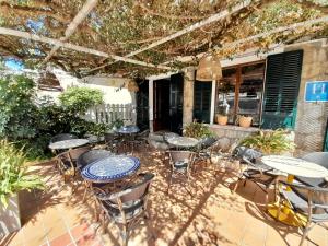 an outdoor patio with tables and chairs and a building at Sol Port Soller in Port de Soller