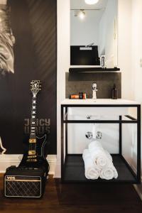 a black and white bathroom with a sink and a guitar at Pyjama Park St. Pauli in Hamburg