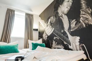 a man sitting on a bed playing a guitar at Pyjama Park St. Pauli in Hamburg